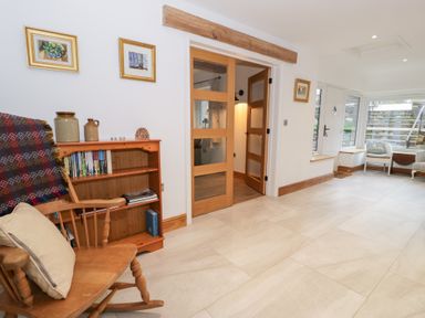 A living room with a rocking chair and bookshelf at Merddwr in Cerrigydrudion