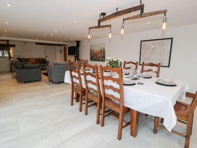 A dining room with a table and chairs and a sofa at Merddwr Cerrigydrudion