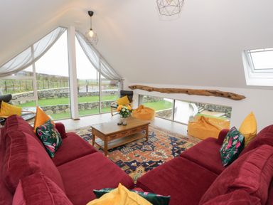 A living room with sofa and table at Merddwr in Cerrigydrudion