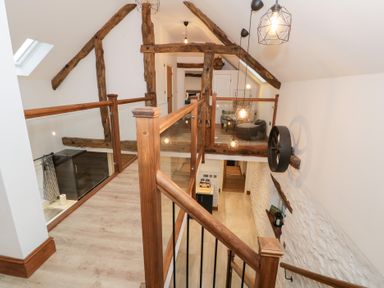 A landing with wooden staircase and light fixtures at Merddwr in Cerrigydrudion