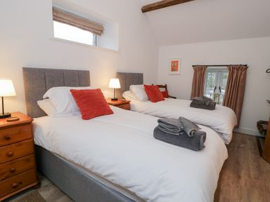 A bedroom with two beds and a window at Merddwr in Cerrigydrudion