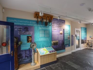 An exhibition room with maritime artifacts and informational panels about Caernarfon at Nantlle in Caernarfon
