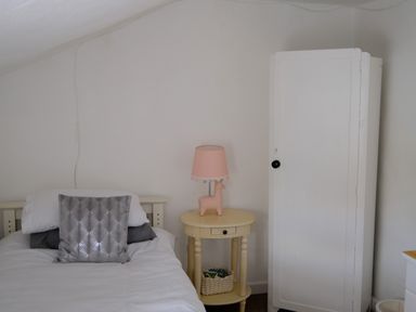 A bedroom with a bed pillow bedside table lamp and a white wardrobe at Phloxhaven in Reedham