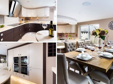 A modern kitchen with dark lower cabinets and white upper cabinets a dining table set with plates wine glasses and a flower vase at Carus House at Carus Green Golf Club Kendal