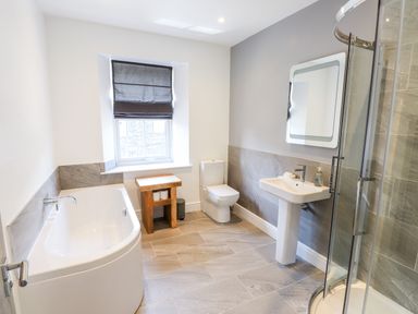 A bathroom with a bathtub toilet sink mirror window and shower at 8 Waterhead Terrace in Ambleside