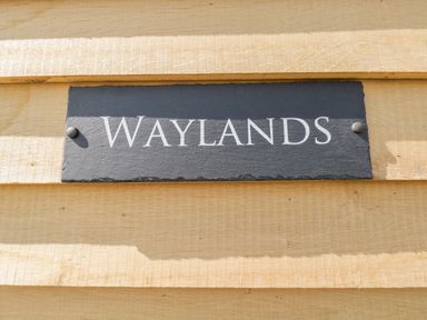 A sign with the word Waylands on a wooden surface at Waylands in Uffington