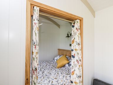 A bedroom with a bed and patterned curtains featuring birds at Waylands in Uffington