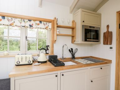 A kitchen counter with a toaster kettle sink stove and microwave at Waylands in Uffington