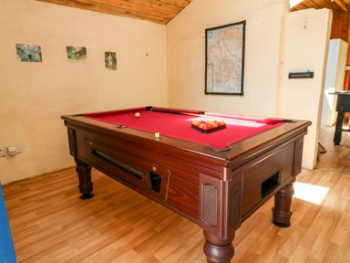 A room with a red pool table and balls arranged for a game at Nattaden @ Fourwinds Meldon near Okehampton