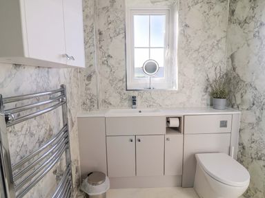 A bathroom with a sink and toilet at West Bay Holiday Home in West Bay