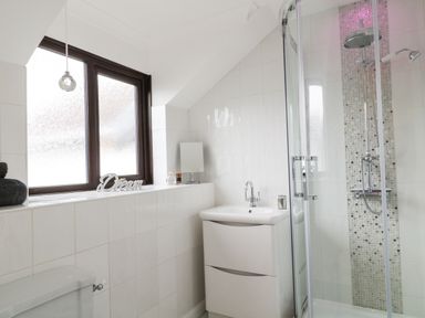 A bathroom with a window a sink a shower and a toilet at 12 Claremont Falls Polperro
