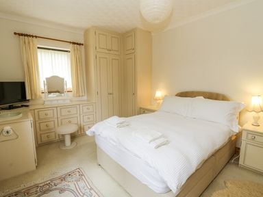 A bedroom with a bed and dresser at Kala in Spittal near Haverfordwest