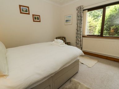 A bedroom with a bed and chair at Kala Spittal near Haverfordwest