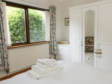 A bedroom with a window and a wardrobe at Kala in Spittal near Haverfordwest