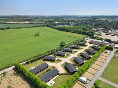 Aerial view of multiple lodges with parking spaces and fields at Oak Lodge in Greetham Rutland