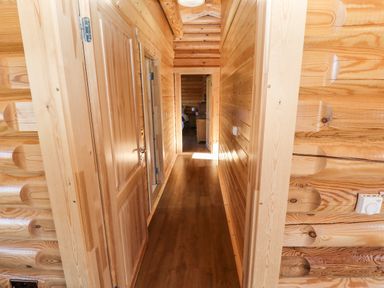 A wooden hallway with doors on the left and right leading to another room at Pine Lodge Greetham Rutland