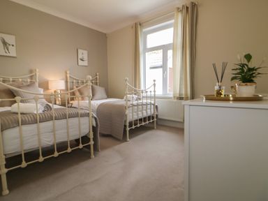 A bedroom with two metal frame single beds and a window at Robin Hill in Duporth near St Austell