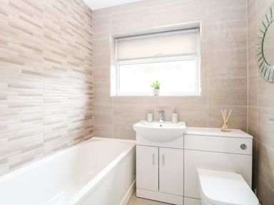A bathroom with a bathtub sink vanity toilet and a window at Harbour Place in Wells-Next-The-Sea