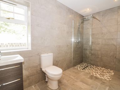 A bathroom with a toilet sink and walk in shower at Kaitkyella Lodge in Scarborough