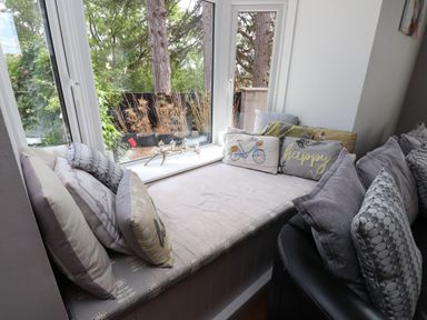 A snug with cushions on a window seat at Tyddyn Elidir near Old Colwyn