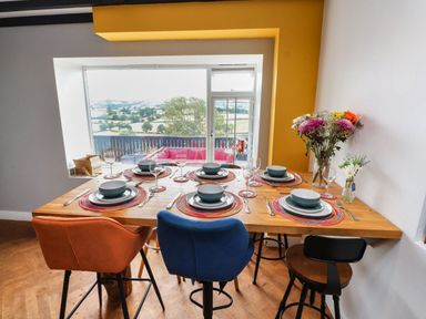 A dining room with a table set for dinner at Tyddyn Elidir near Old Colwyn