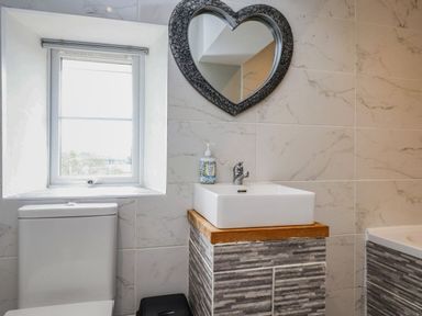A bathroom with a toilet and sink in Tyddyn Elidir near Old Colwyn