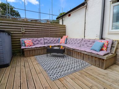 An outdoor seating area with cushioned seating and a coffee table at Tyddyn Elidir near Old Colwyn
