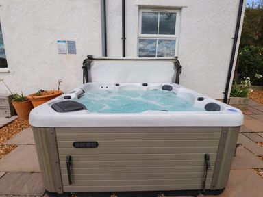 A hot tub with water in a garden at Tyddyn Elidir near Old Colwyn