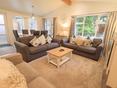 A living room with two sofas a coffee table and a dining table with chairs at Cherry Tree Lodge Calgarth 37 White Cross Bay near Windermere