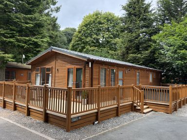 A wooden lodge with decking at Cherry Tree Lodge, Calgarth 37, White Cross Bay near Windermere