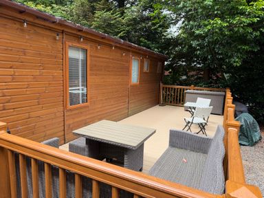 An outdoor area with a wooden cabin and seating at Cherry Tree Lodge, Calgarth 37, White Cross Bay near Windermere