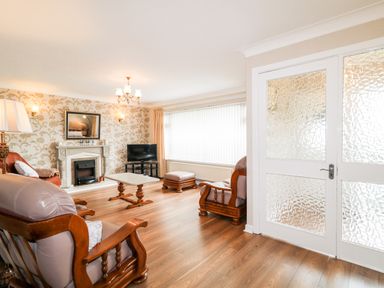 A living room with wooden furniture a coffee table a fireplace and a TV at 27 Pinewood Hill Warrenpoint Northern Ireland