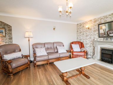 A living room with leather sofas wooden coffee table and fireplace at 27 Pinewood Hill Warrenpoint Northern Ireland