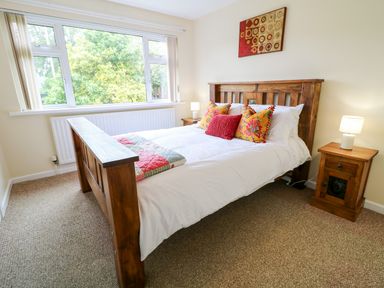 A bedroom with a wooden bed and bedside tables with lamps at 27 Pinewood Hill in Warrenpoint Northern Ireland