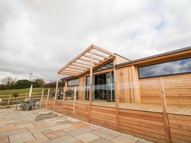 Outdoor patio area with wooden deck and pergola at Stables Lodge in Wingerworth