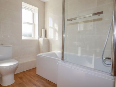 A bathroom with a toilet bathtub and a window at Ilgram in St Newlyn East