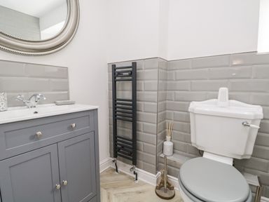 A bathroom with a sink cabinet mirror toilet and radiator at Bella Cottage Bolton near Appleby-in-Westmorland