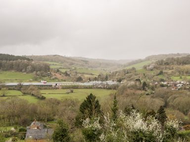 A rural landscape with hills fields trees and scattered houses at Sevenwoods View in Longhope