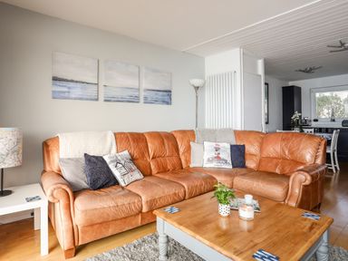A living room with a brown leather sectional sofa and wooden coffee table at The Summerhouse in Y Felinheli