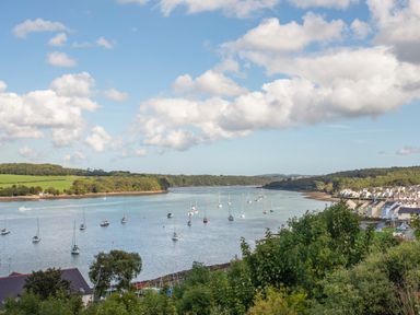 A river with boats and houses along the shore surrounded by trees at The Summerhouse in Y Felinheli