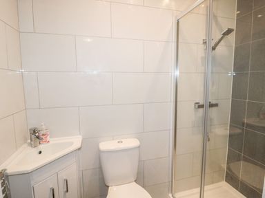 A bathroom with a corner sink unit toilet and a shower enclosure at Sea View Lodge in Eastfield Hall near Warkworth