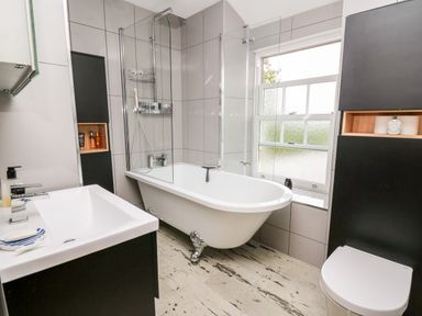 A bathroom with a bathtub shower sink and toilet at Dolwern in Dinas Cross