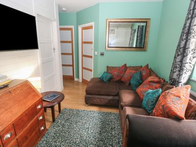 A living room with a couch and television at Llys-Yr-Onnen in Carmarthen