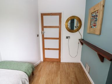 A bedroom with a bed and wall decor at Llys-Yr-Onnen in Carmarthen
