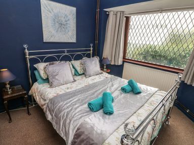 A bedroom with a bed and window at Llys-Yr-Onnen in Carmarthen