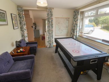 A snug with an air hockey table and a sofa at Penmarth House in Coverack