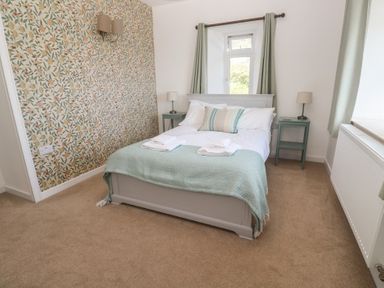 A bedroom with a bed and bedside tables at Penmarth House in Coverack