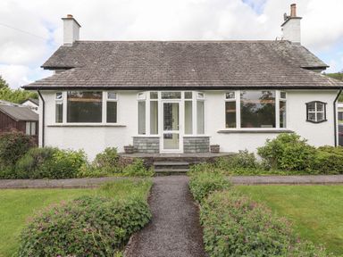 A front view of a single-story house with a pathway and garden at Halewood in Bowness-On-Windermere