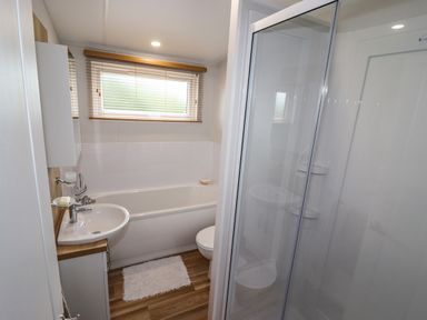 A bathroom with a shower, bathtub, sink, and toilet at Bramblewick in Runswick Bay near Staithes