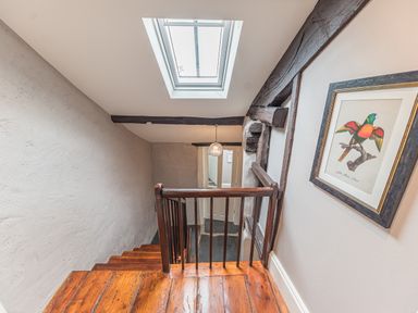 A staircase with wooden steps a skylight and a framed picture of a bird at Old Toffee Shop in Ambleside